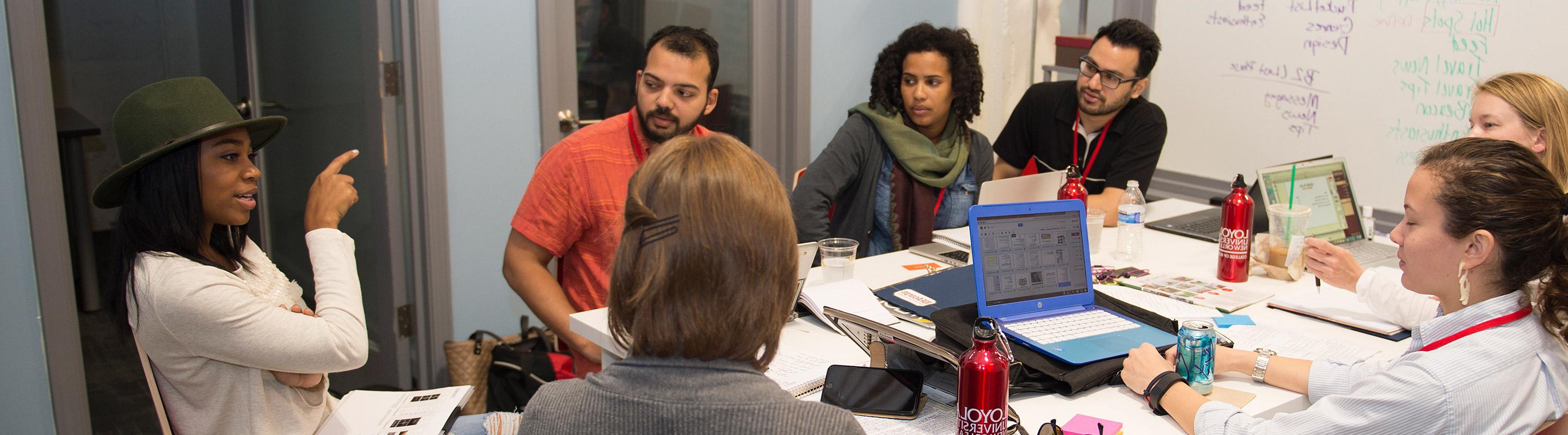 Students around table discussing project 